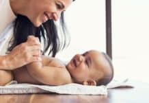 Mother changing diaper to toddler