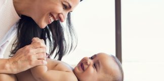 Bababarát fürdőszoba Mother changing diaper to toddler
