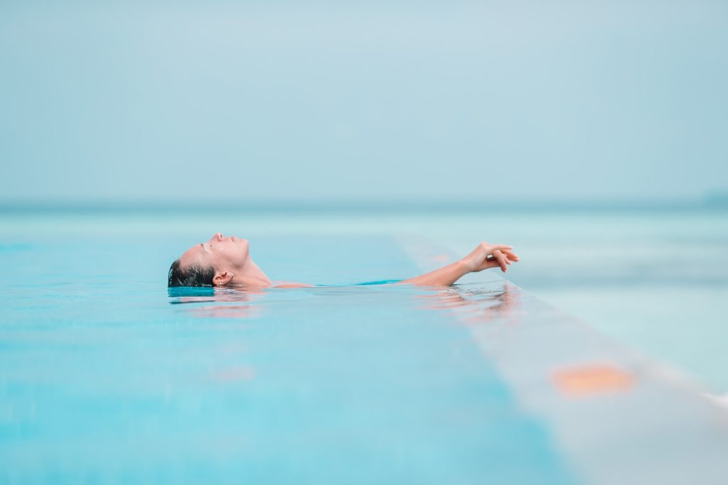 A fagyban se feledkezz meg kültéri medencédről! Hogyan téliesítsd? Young beautiful woman enjoying summer vacation in luxury pool