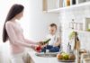 Így varázsolhatod gyerekbiztossá a konyhád! Mom with baby washing vegetables at kitchen, empty space