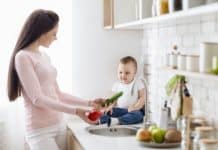 Így varázsolhatod gyerekbiztossá a konyhád! Mom with baby washing vegetables at kitchen, empty space