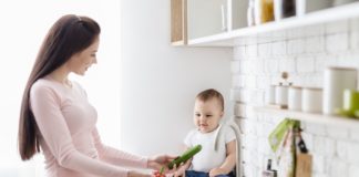 Így varázsolhatod gyerekbiztossá a konyhád! Mom with baby washing vegetables at kitchen, empty space
